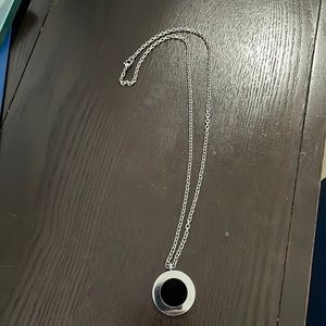 Silver chain with silver and black charm. 11.5 inches long.